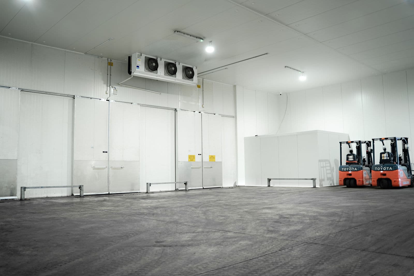 Wide view of the cold store at the Darwin depot, roller doors and forklifts