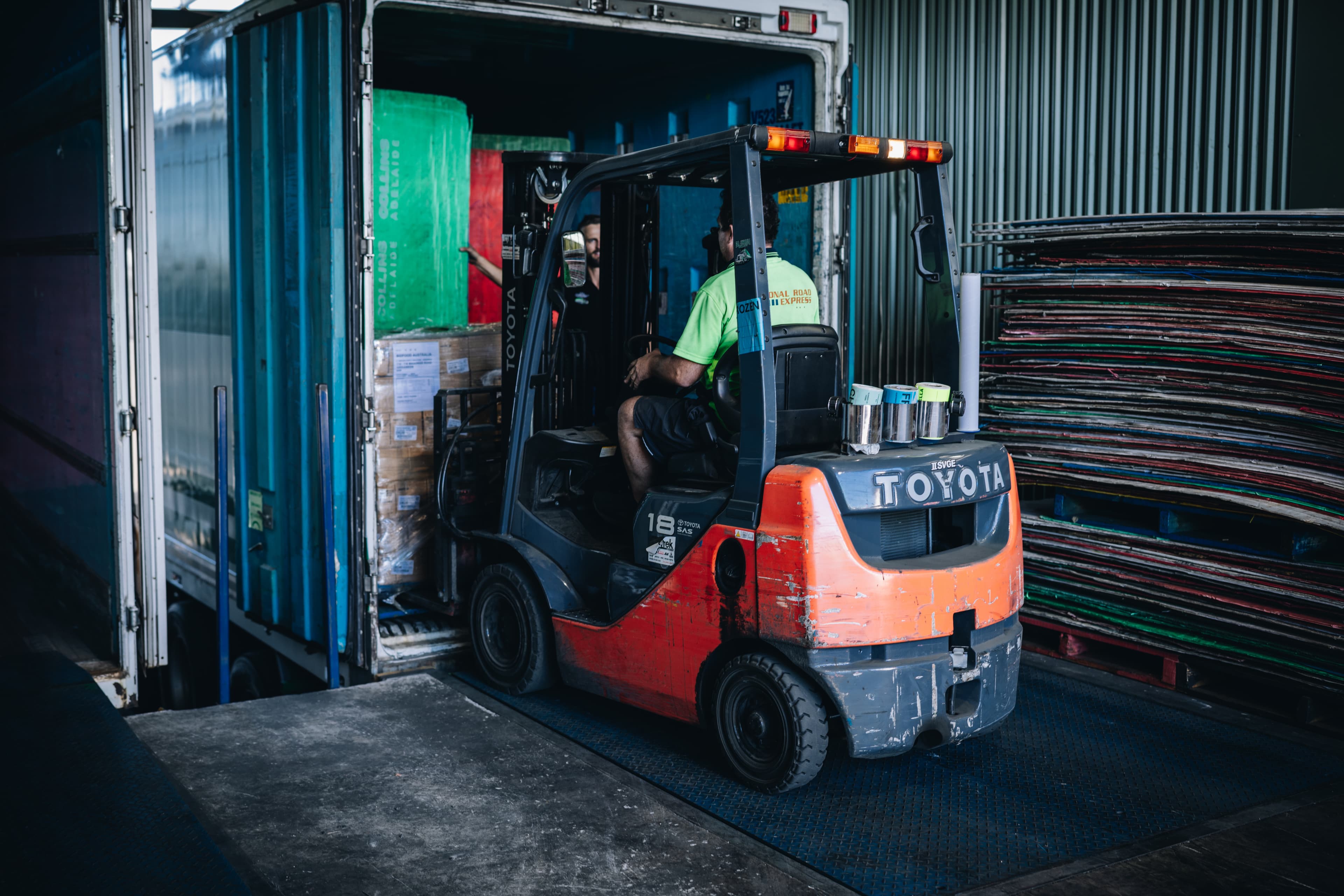 Forklift loading palletised freight into a refrigerated trailer