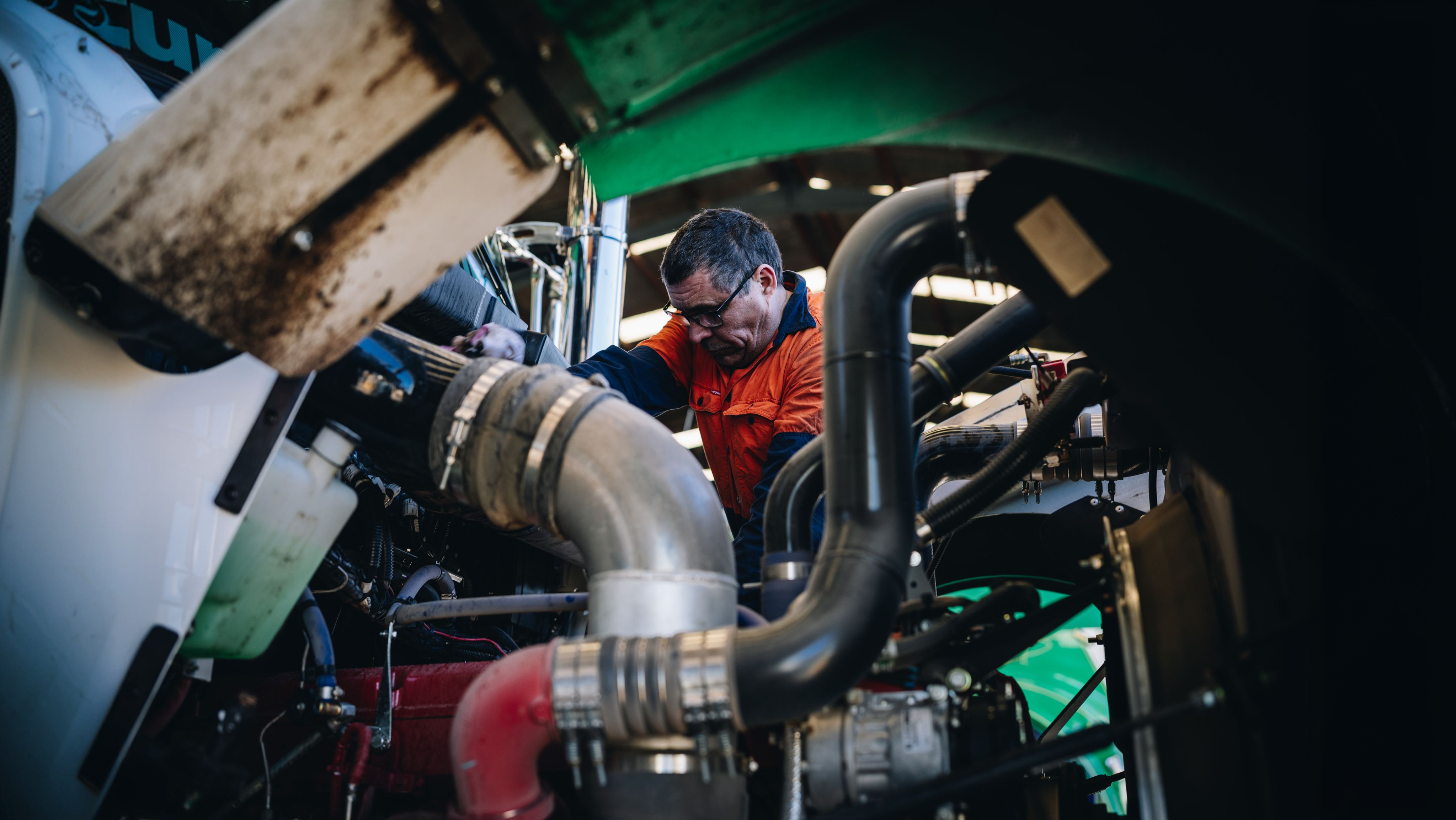 Diesel mechanic working on a Cummins engine in the Scarcella workshop